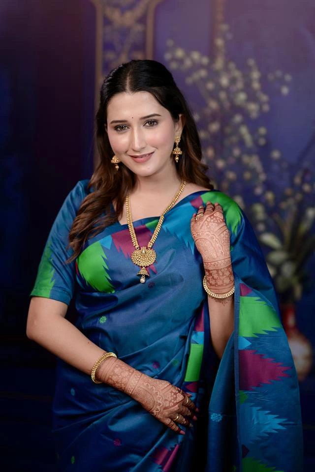 Woman in a colorful saree with jewelry against a dark background